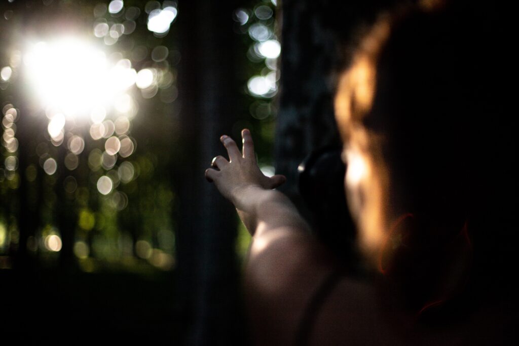 woman's hand reaching out for help in the forest