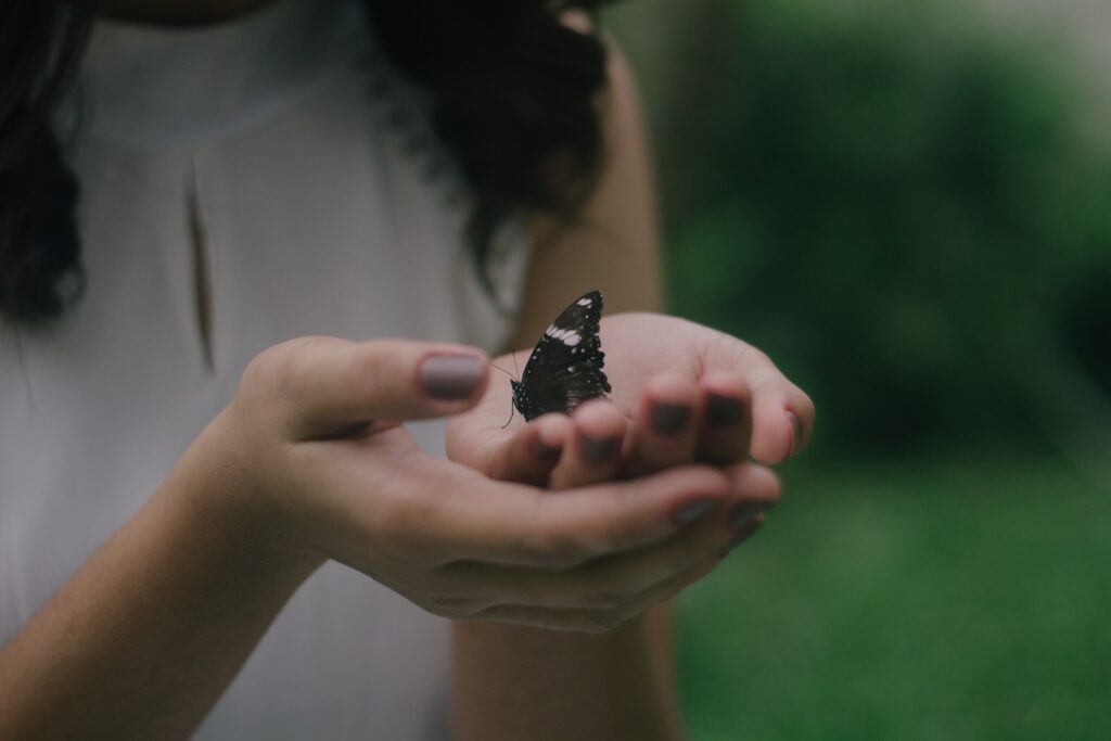 Woman holding a butterfly in her hands