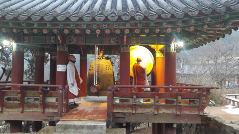 Two monks about to ring a bell in a Korean temple